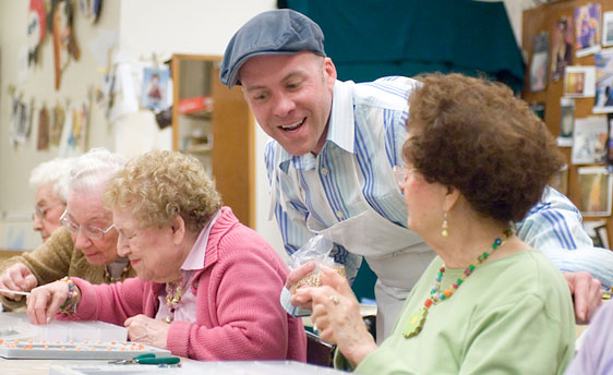 young man discusses beadmaking with resident