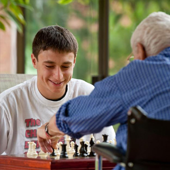 Volunteer shows a yoga position to a resident