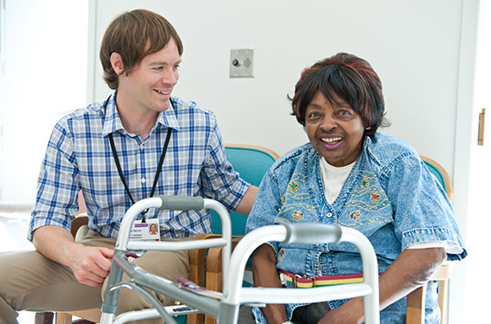 Rehabilitation staff and patient laughing and socializing in the STARS unit atrium